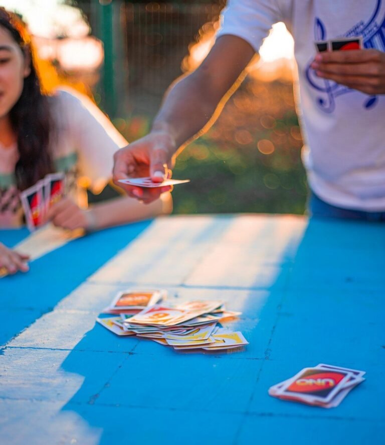Family playing the card game Uno outside on a summer day.