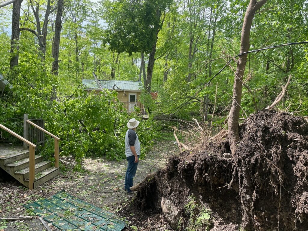 A camp, damaged by a derecho storm that knocked down trees and power lines, recovers thanks to families who volunteer to help clean up.